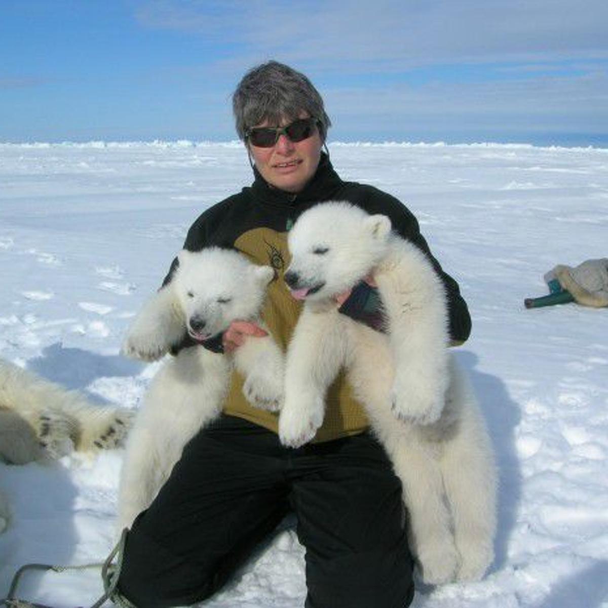 A photo of Merav Ben David, holding two bear cubs